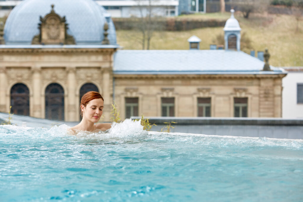 Eine Frau genießt ein Bad im Außenbecken des Palais Thermal in Bad Wildbad
