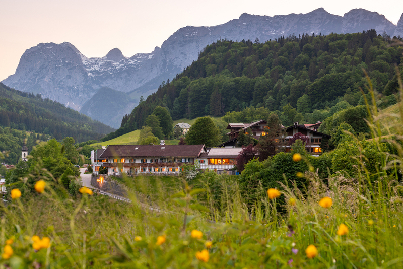 Außenfoto des Berghotel Rehlegg in Ramsau von saftigen Almwiesen aus gesehen