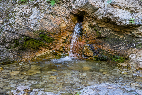 Mineralquelle fließt aus Gestein