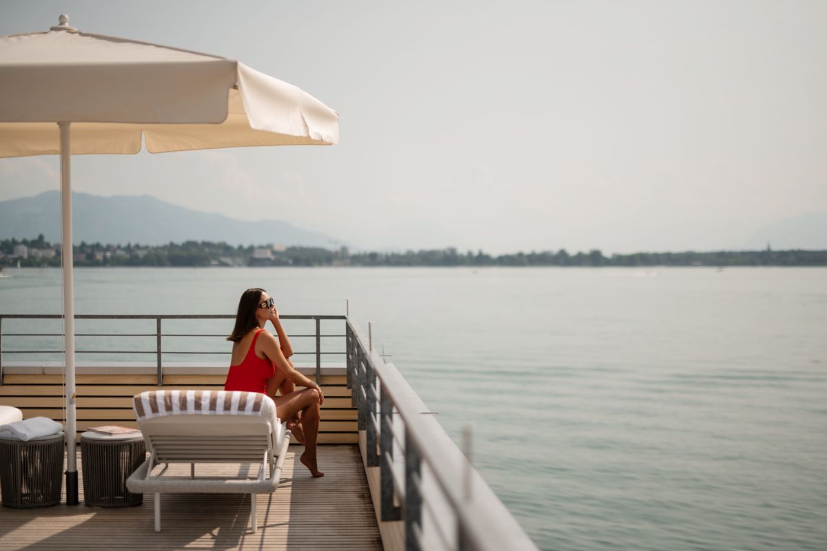 Frau auf Terrasse des Badehauses am Kaiserstrand